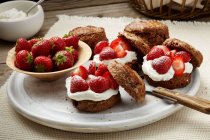 Schokoladen-Dinkel-Scones mit Schlagsahne und frischen Erdbeeren — Stockfoto