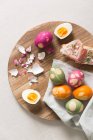 Easter eggs and open ham sandwiches on a wooden plates — Stock Photo