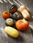 Various pumpkins on a wooden surface — Stock Photo