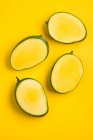 Mango halves against a yellow background (top view) — Stock Photo