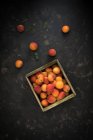 Holzkiste mit Aprikosen auf dunkler Oberfläche — Stockfoto