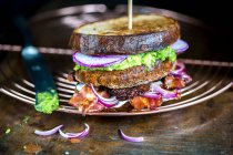 Un panino rustico con verdure e pancetta — Foto stock