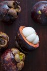 Frutta tropicale intera e affettata su tavola di legno — Foto stock