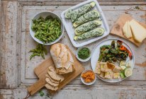 Verschiedene Vorspeisen: Edamame, gefüllte Zucchini, Pimientos, Brot und Käse — Stockfoto