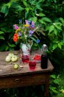 La cuajada de grosella y el césped de grosella en la mesa de verano en el jardín - foto de stock