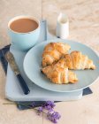 Croissants with almond flakes, served with tea — Stock Photo