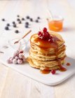 Stacked pancakes with syrup and berries — Stock Photo