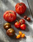 Tomates rojos frescos sobre tabla de madera - foto de stock