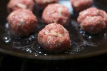 Raw meatballs being fried in a pan — Stock Photo