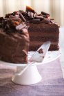 Un pastel de crema de chocolate de tres capas, en rodajas - foto de stock