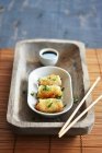 Spring rolls in a bowl with soy sauce on a rustic tray with chopsticks — Stock Photo