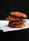 Una pila di biscotti di farina d'avena su carta su uno sfondo nero — Foto stock