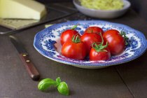 Tomates frescos y albahaca en un plato - foto de stock