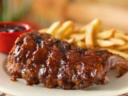 Spare ribs with barbecue sauce and fries — Stock Photo