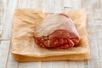 Raw leg of lamb on baking paper — Stock Photo