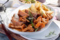 Goose breast with chanterelle mushrooms and roast potatoes — Stock Photo