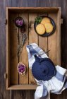 Thé vert dans une casserole et une tasse, fleurs comestibles, herbes et biscuits dans une boîte en bois — Photo de stock