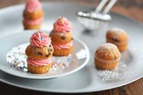Small muffins with buttercream, icing sugar and sugar sprinkles — Stock Photo