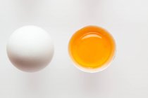 Huevos blancos, uno abierto - foto de stock