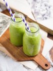 Grüner veganer Smoothie in zwei kleinen Flaschen — Stockfoto
