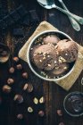 Sorvete de chocolate e avelã em uma tigela de prata com nozes picadas — Fotografia de Stock