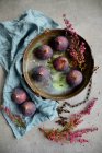 Figues fraîches sur plaque métallique rustique avec des fleurs séchées et tissu — Photo de stock