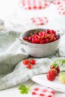 Grosellas y fresas en un tazón de conservación - foto de stock
