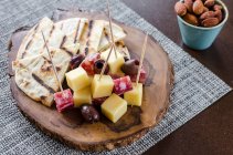 Fleischwurst und Käseplatte mit Würfeln von Salami und Weichkäse mit Kalamata-Oliven und Focaccia-Brot auf einem Holzbrett — Stockfoto