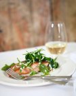 Gebratener Lachs mit Bocconcini, frischen Kräutern und Sauerrahmdressing, Weißwein im Hintergrund — Stockfoto