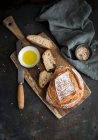 Pan a bordo con aceite de oliva y tazón de sal himalaya sobre tela - foto de stock