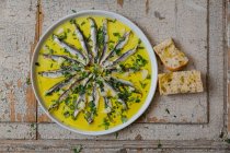Alici in olio d'aglio servite con erbe e pane (vista dall'alto) — Foto stock