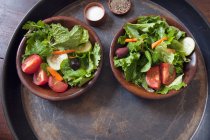Salade verte vinaigrette en feuilles dans des bols en bois — Photo de stock