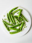 Piselli verdi freschi su sfondo bianco — Foto stock