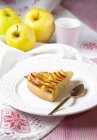 Una rebanada de tarta de manzana y manzanas frescas - foto de stock