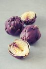 Bébé artichauts violets, entiers et coupés en deux — Photo de stock