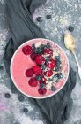 Bol smoothie aux fraises avec yaourt, framboises, bleuets, avoine et flocons de noix de coco — Photo de stock