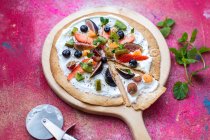 Fruit Pizza made from a toasted Tortilla wrap base, with natural yogurt, fresh fruit toppings, chia seeds and mint to garnish — Stock Photo