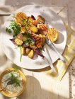Печеная курица с картофелем и овощами на белой тарелке — стоковое фото