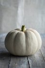 A small white pumpkin on a wooden surface — Stock Photo