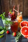 Vari bicchieri da cocktail fruttati, barattolo e bottiglia — Foto stock