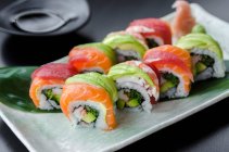 Japanese platter of rainbow rolls maki, inside out seaweed and rice roll — Stock Photo