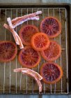 Rodajas de naranja sangre y cáscara de naranja sangre confitada - foto de stock