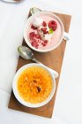 Raspberry cream and creme brulee in small bowls — Stock Photo