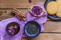 Зеленый чай с корицей палочки, съедобные цветы и печенье — стоковое фото
