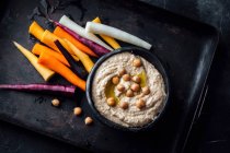 Хумус и разноцветные морковные палочки — стоковое фото