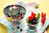 Свіжі літні фрукти в скляному і металевому ситі — стокове фото