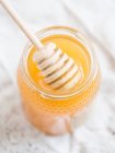 A jar of Portuguese honey with a honey dipper (close-up) — Stock Photo