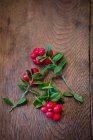 Sprigs of lingonberries on a wooden surface — Stock Photo