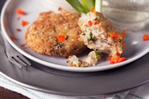Partially eaten small crab cakes with red pepper — Stock Photo