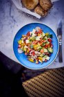 Знімок смачного грецького салату на синій тарілці. — стокове фото